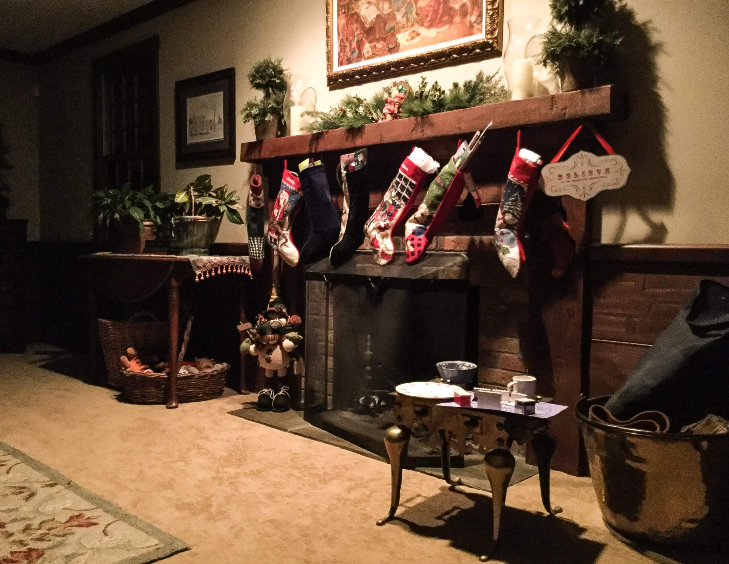 A living room is shown, including a fireplace with several Christmas stockings hung from the mantel.
