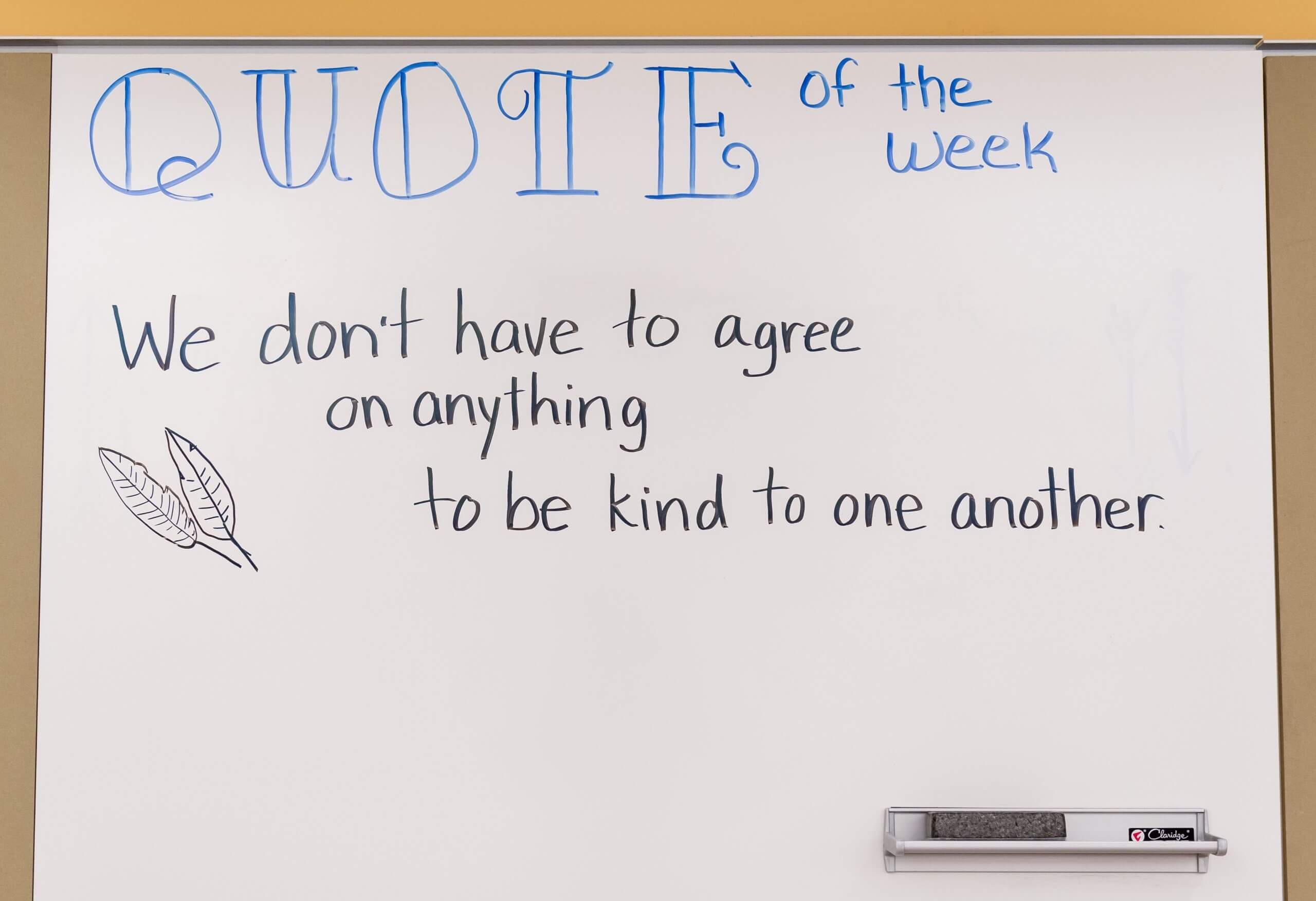 Handwritten letters on a whiteboard read as follows. Quote of the week. We don't have to agree on anything to be kind to one another.