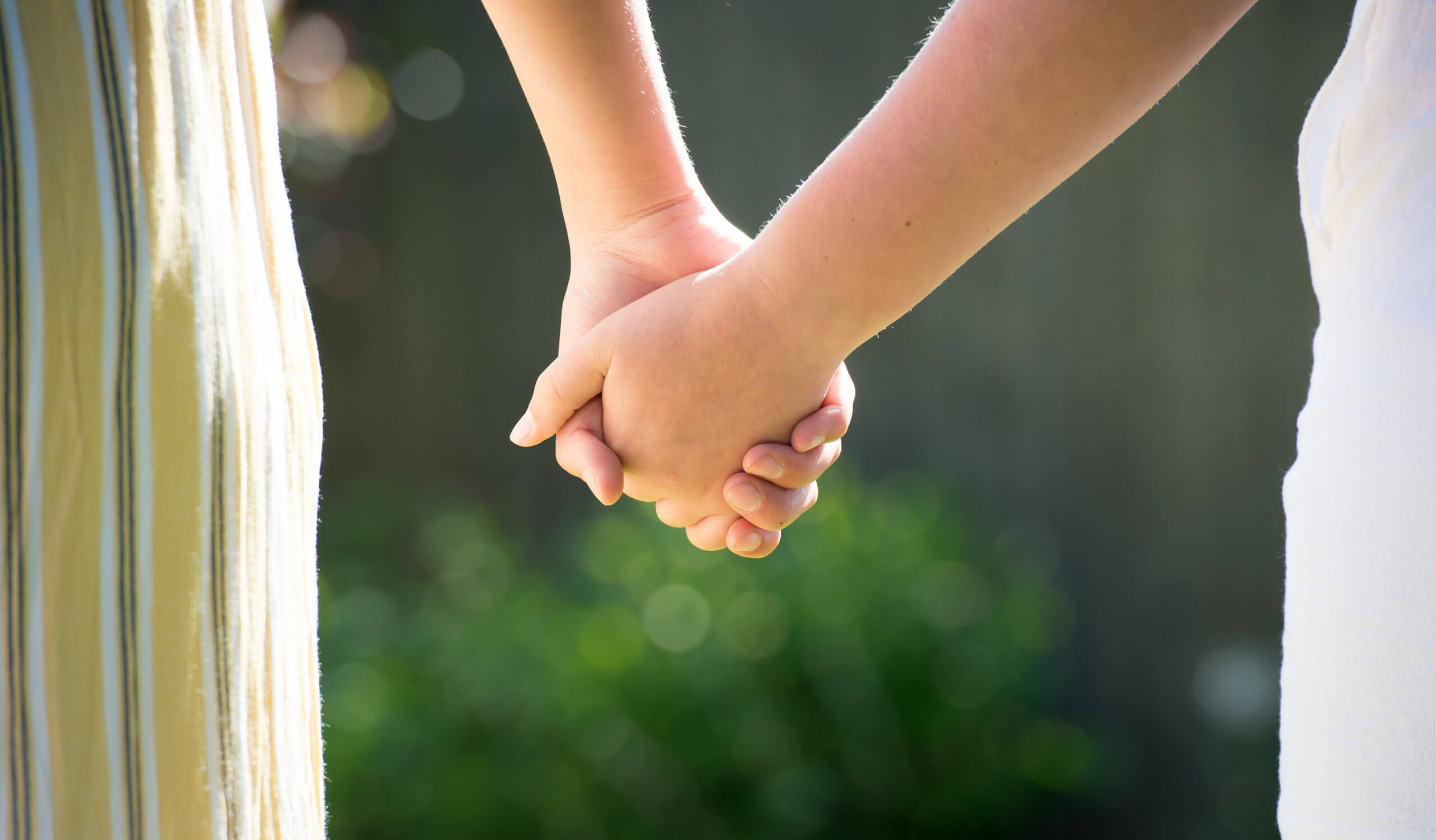 Two individuals hold hands.