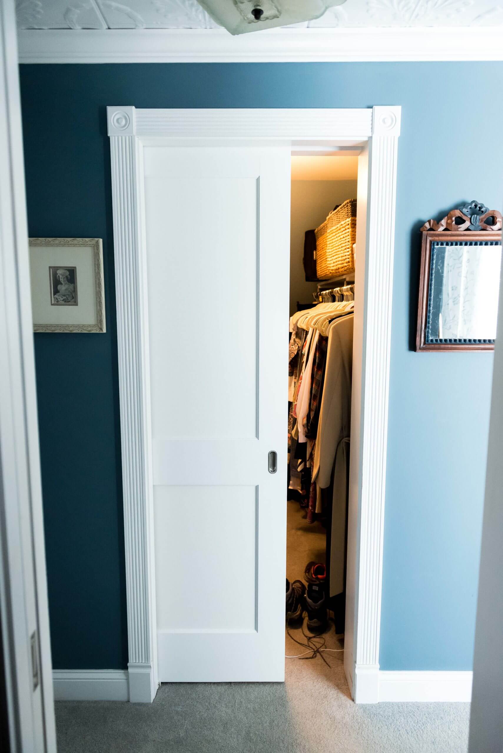 A view outside of a closet. The door is halfway open and the light is on.