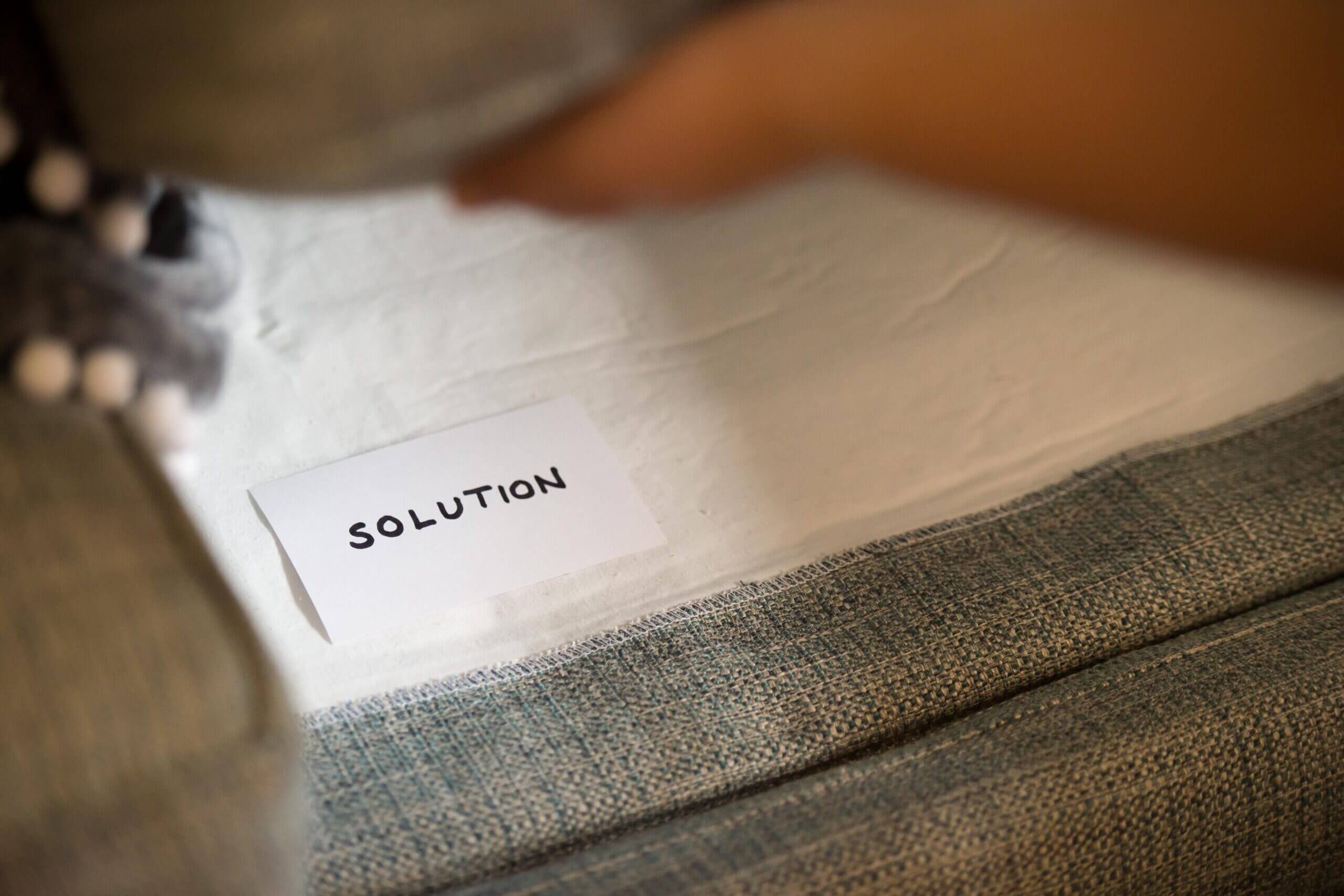 An unfocused view of a paper with text. A focused view shows the word, solution.