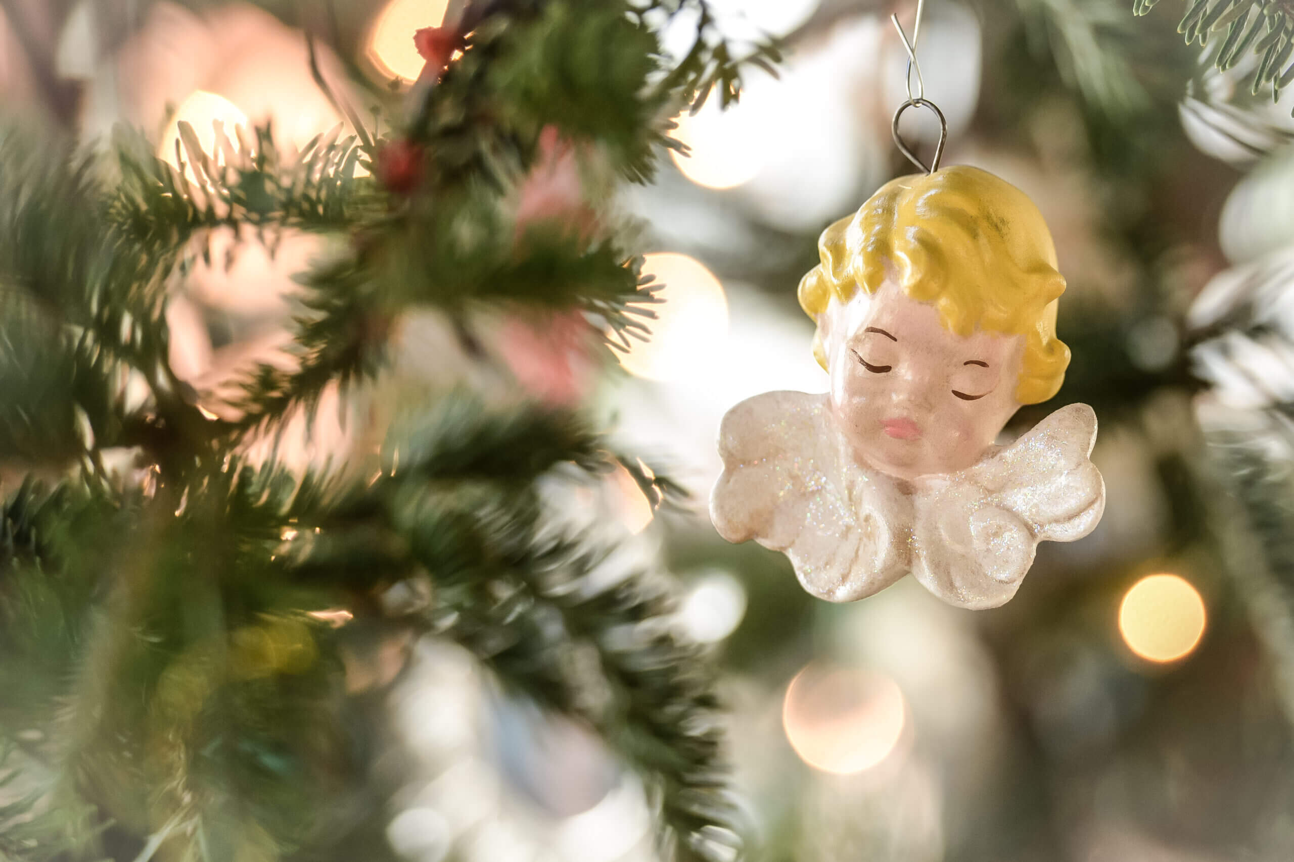 An angel ornament on a Christmas tree.