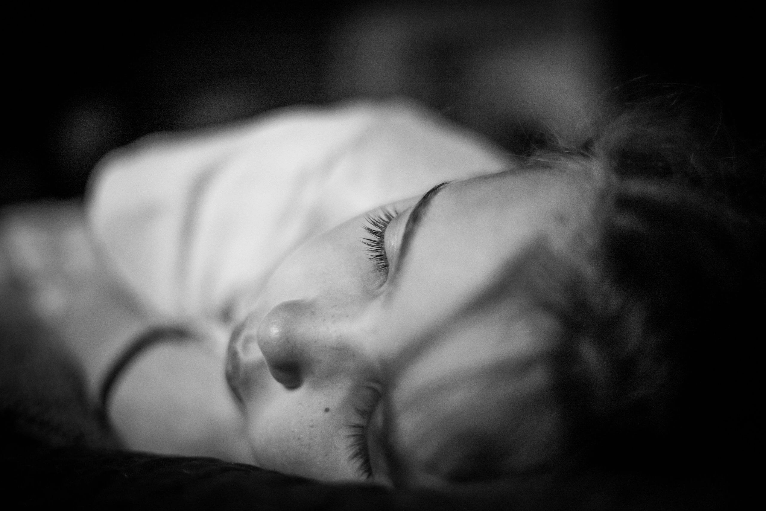 Black and white photo of a young girl sleeping on her left side taken from the perspective of the top of her head
