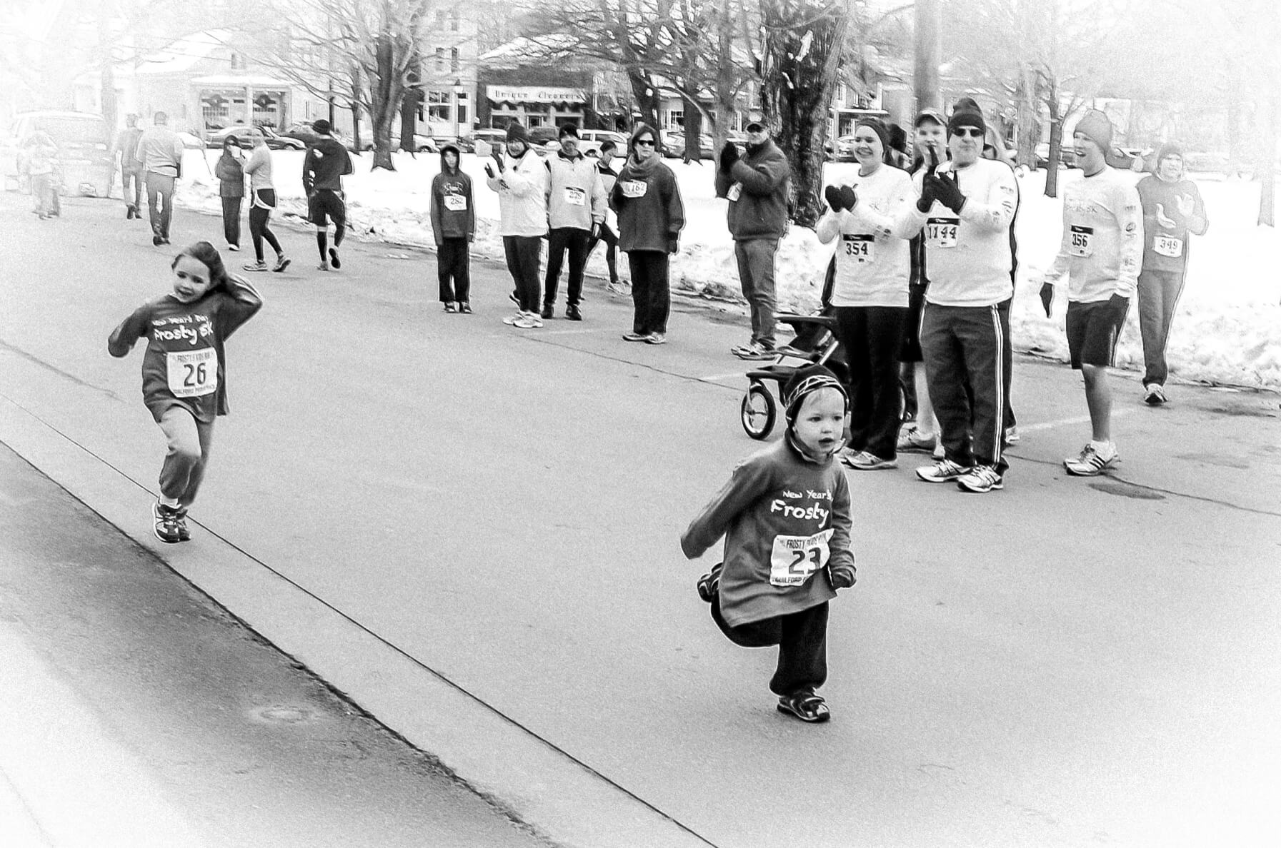 Black and white photo of a four year old white boy finishing a Frosty 5K running race.