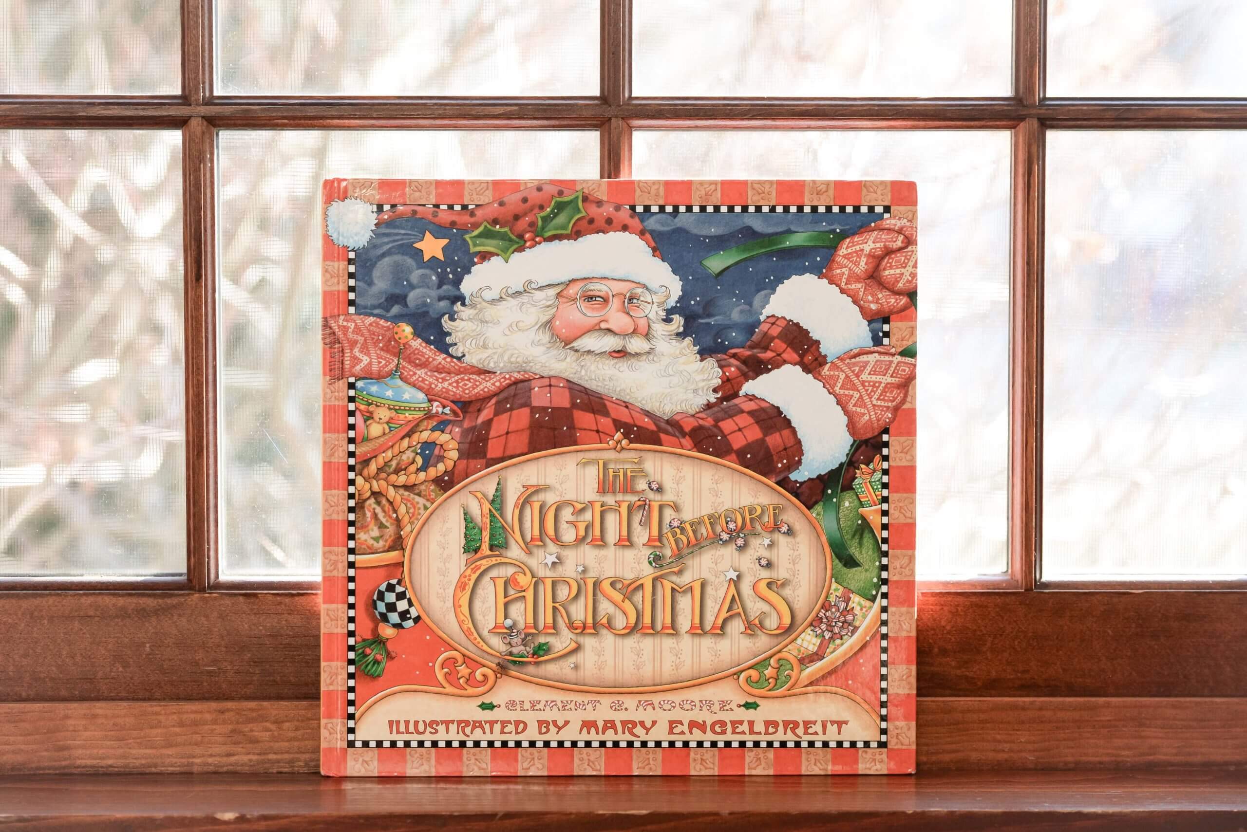 Color photo of The Night Before Christmas book sitting on a window ledge. The book is illustrated by Mary Engelbreit