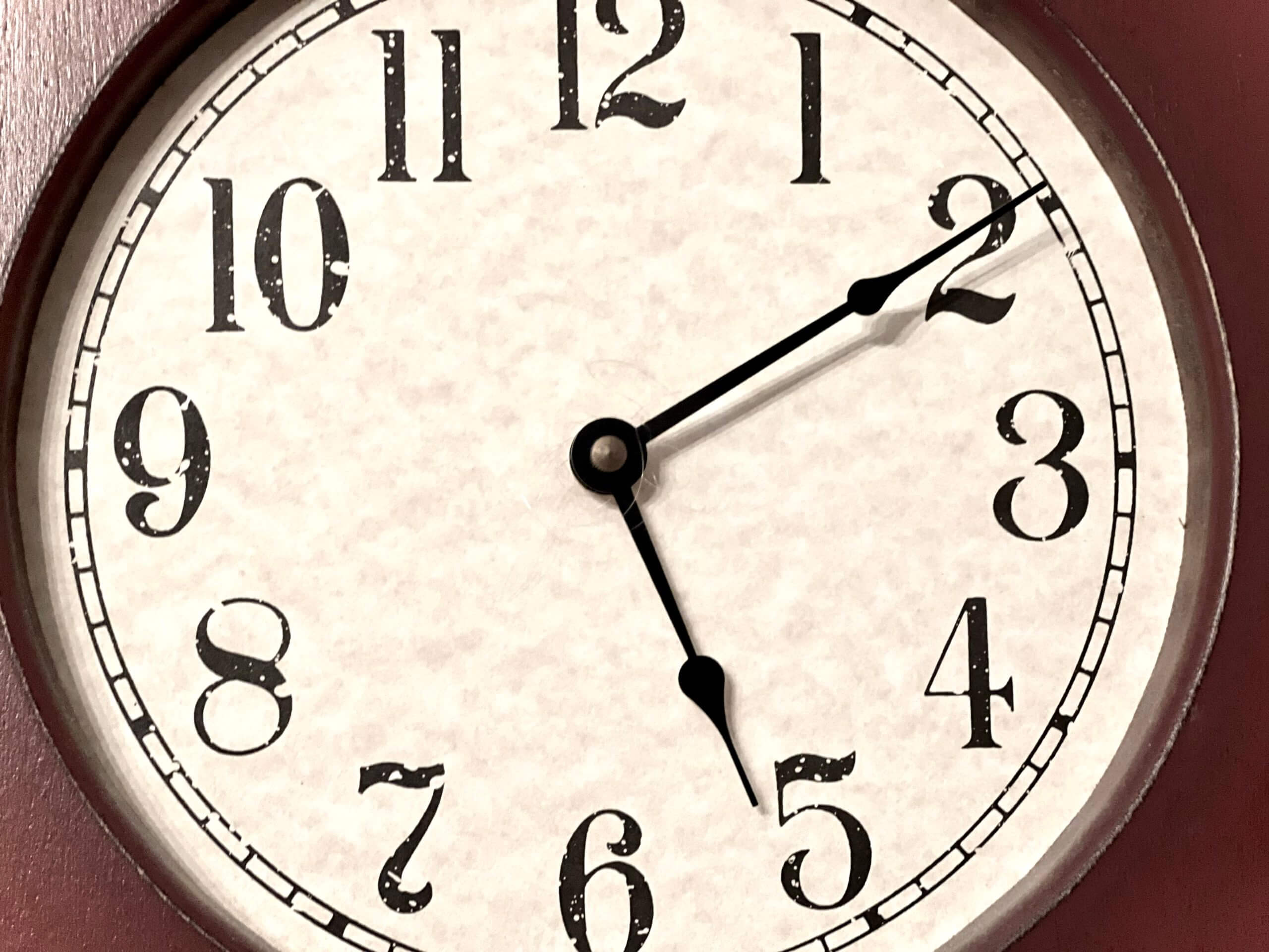Close-up image of an analog clock that reads 5:10.