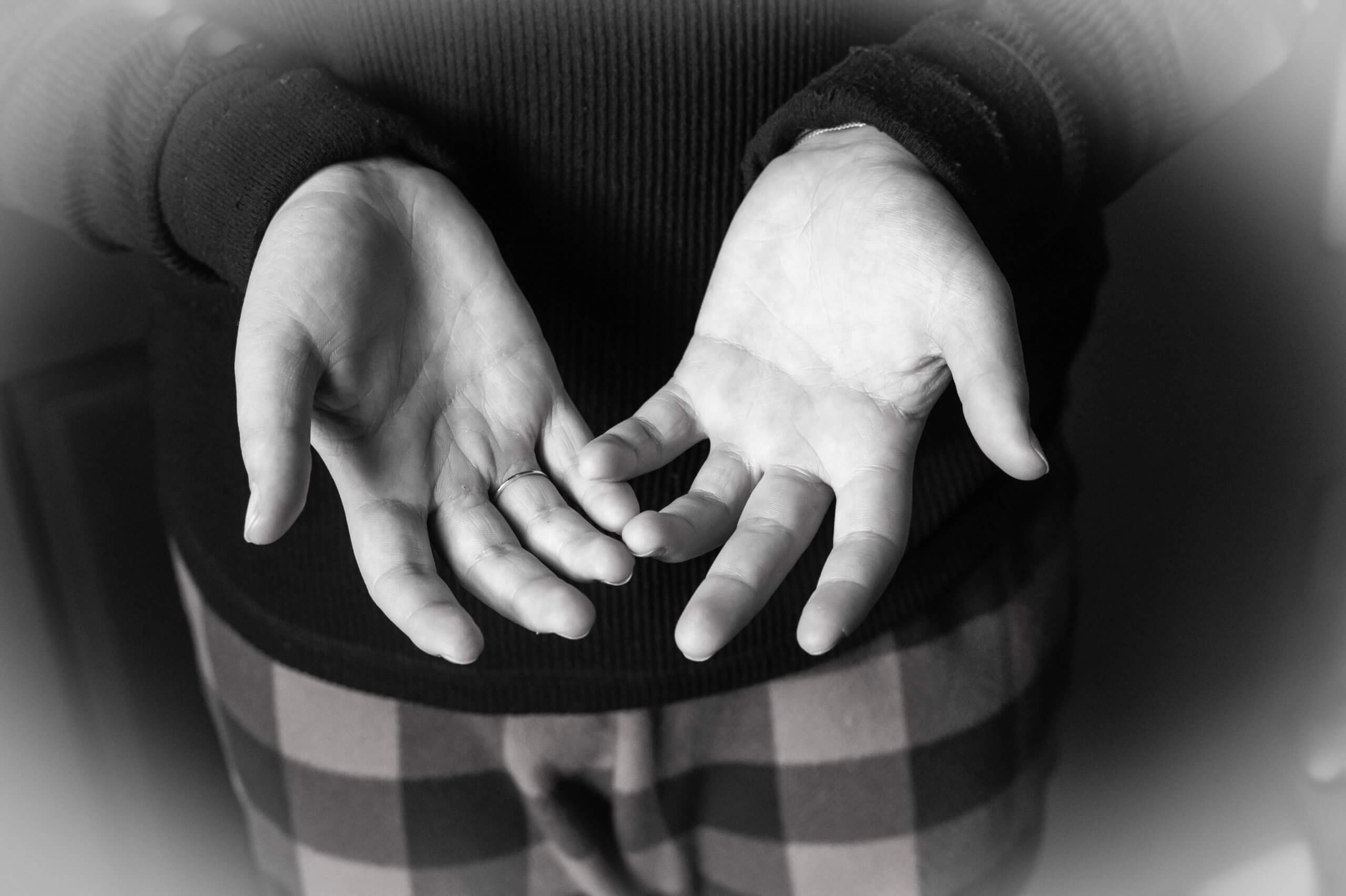 Black and white image of a close-up on hands facing palms up.