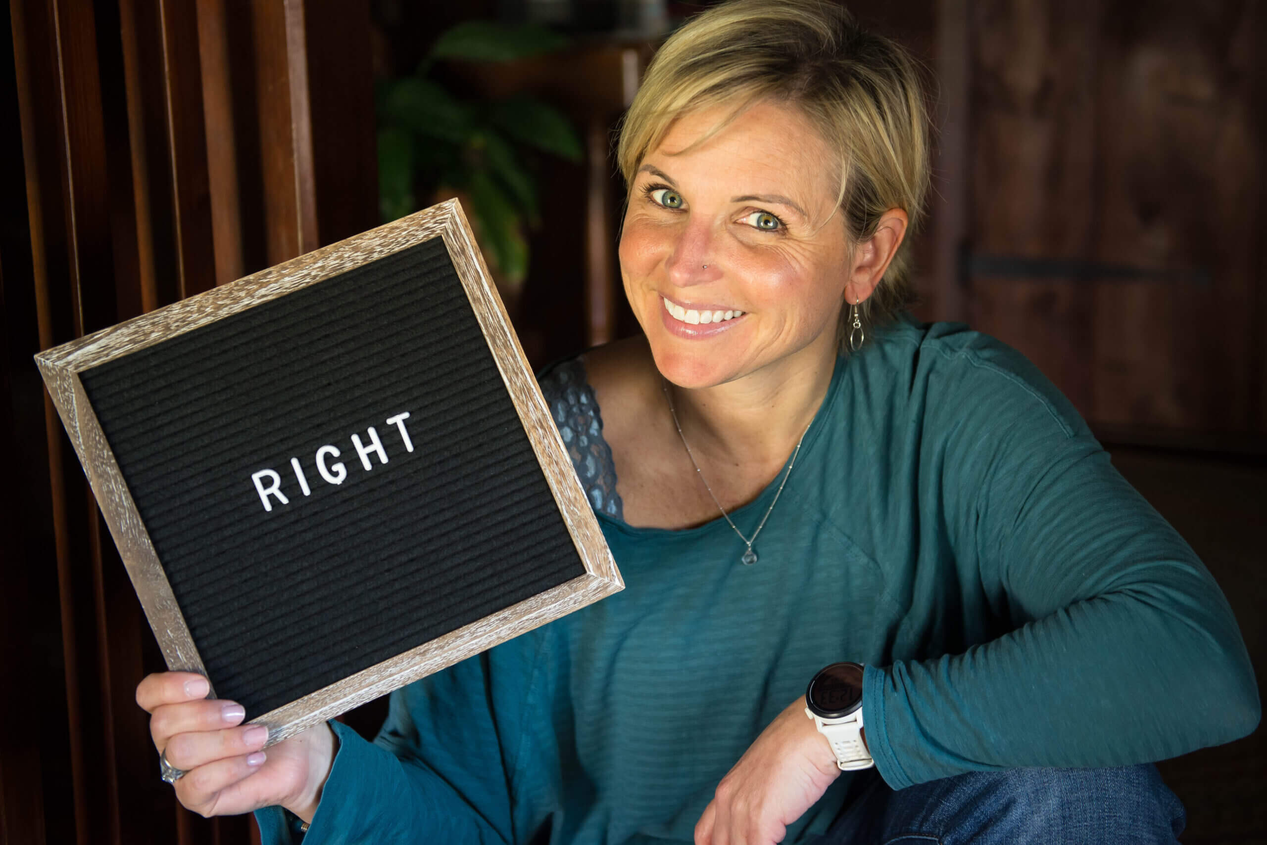 Color photo of a white woman holding a sign with the word "RIGHT" on it.