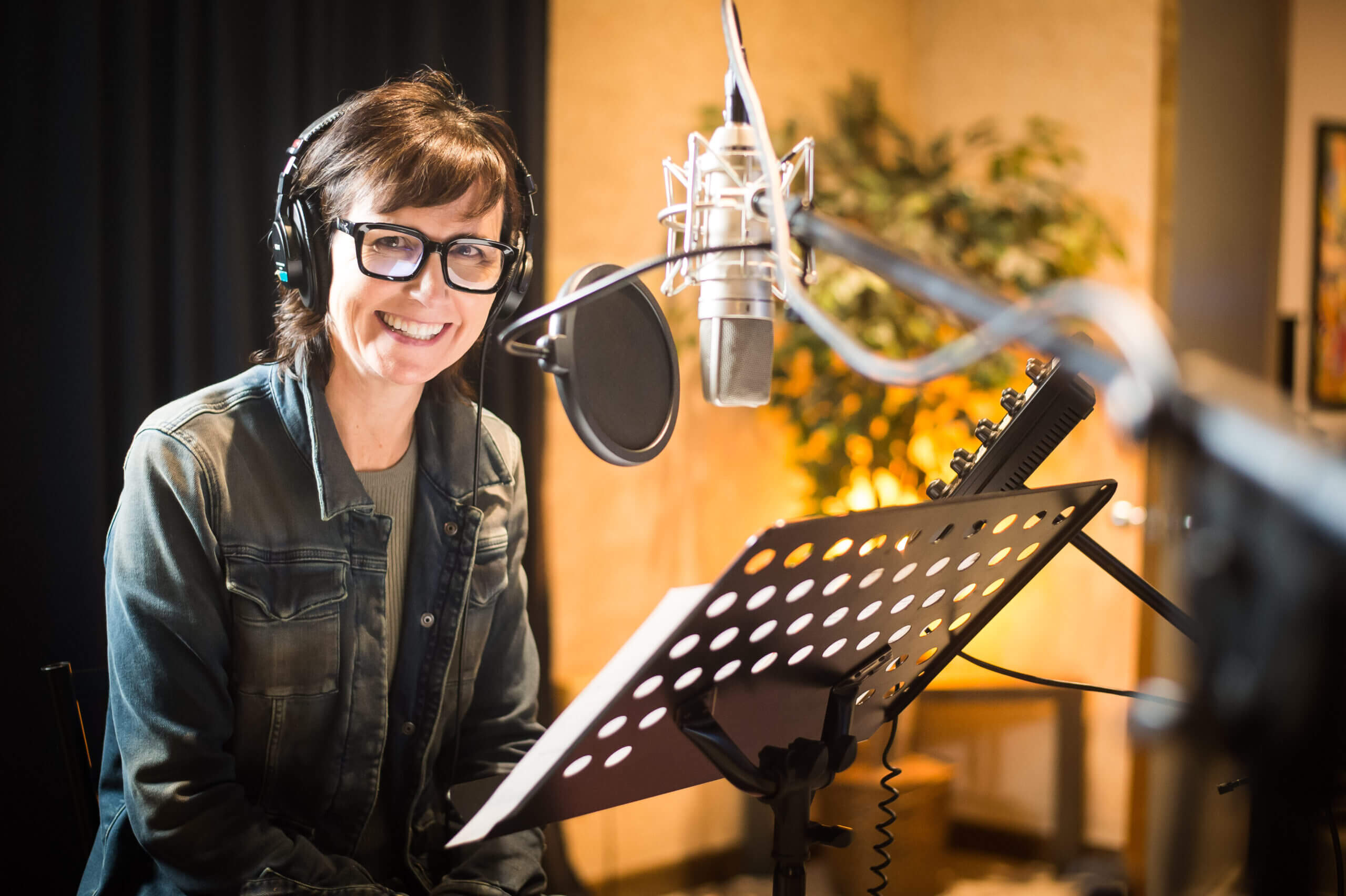 Color image of Julie Fitzpatrick recording a podcast episode for Confessions of a Recovery Micromanaging Perfectionism Martyr.