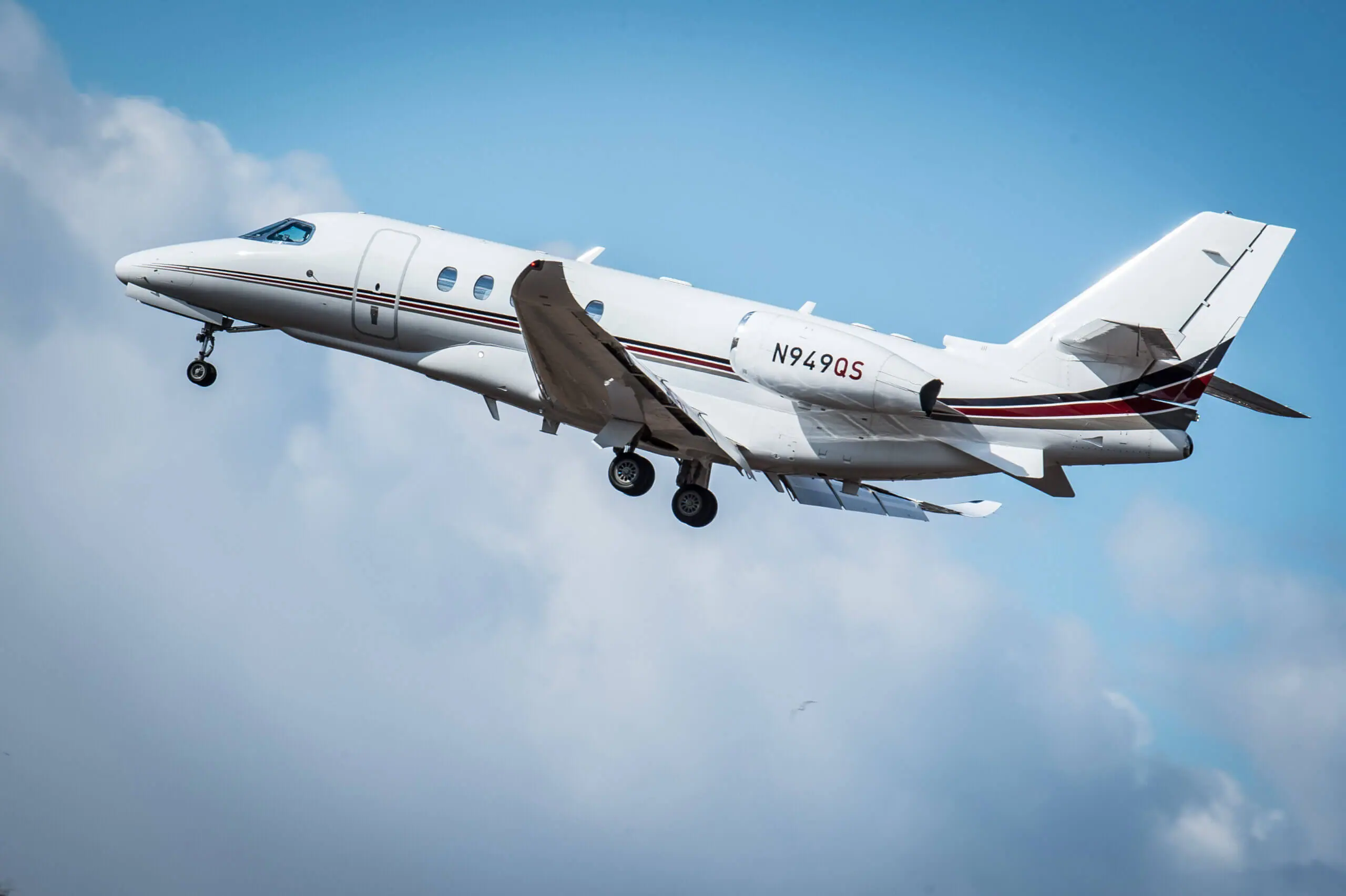 Color image of a small white plane in the sky.