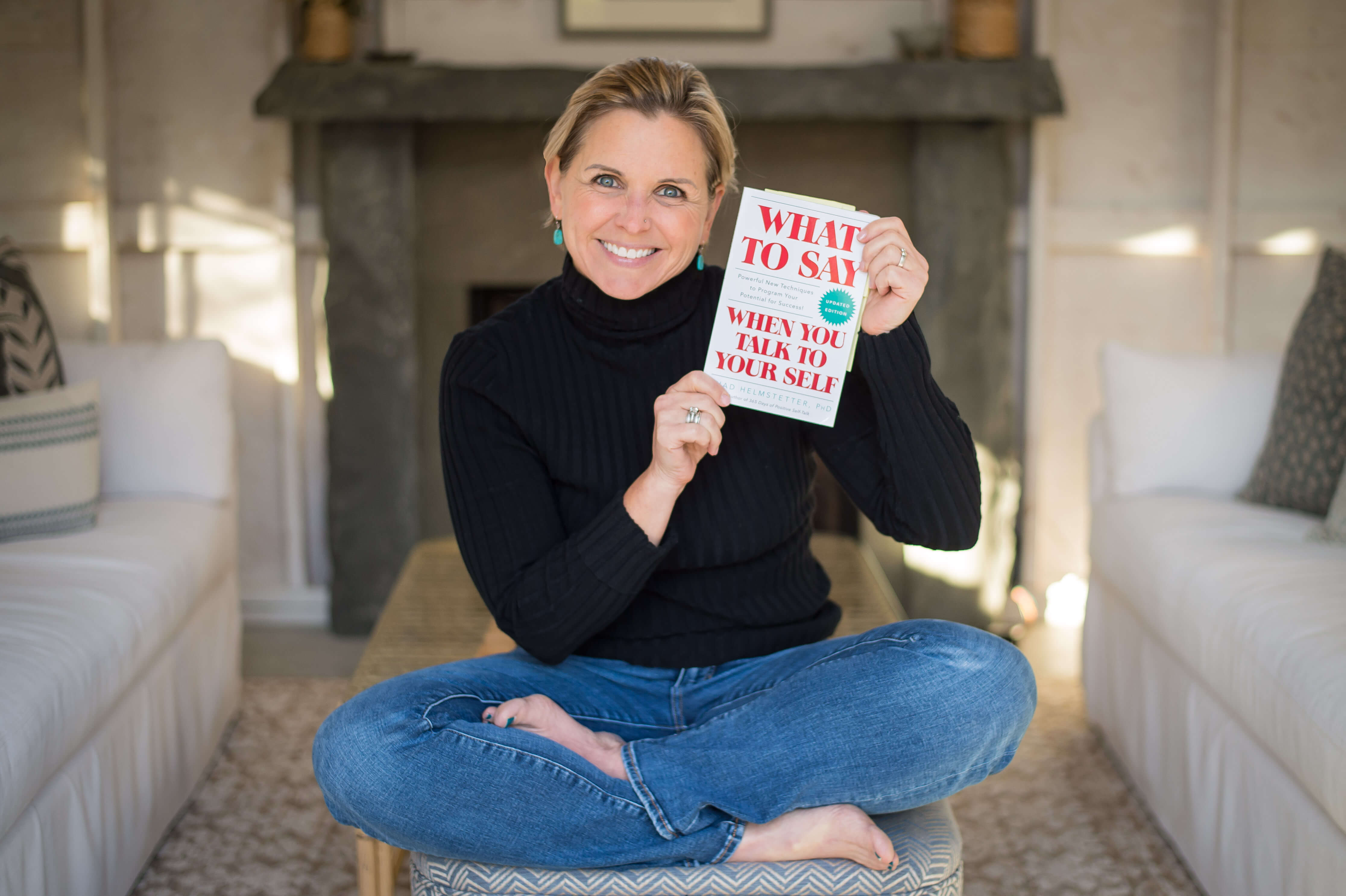 Image of a middle aged white woman holding the book What to Say When You Talk to Yourself by Shad Helmstetter.