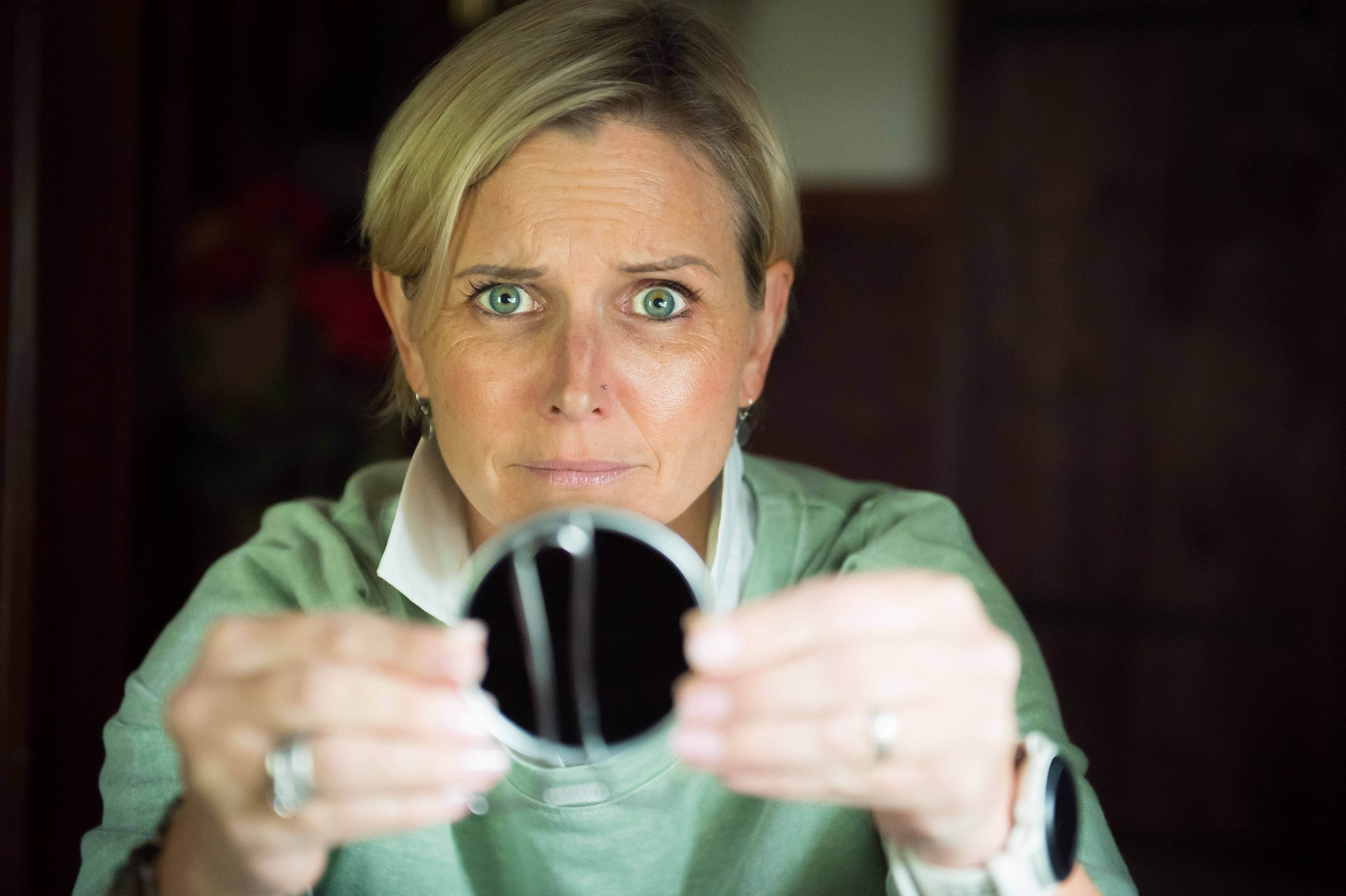 Color image of a blonde woman looking at the camera with tension in her face, highlighting forehead wrinkles.